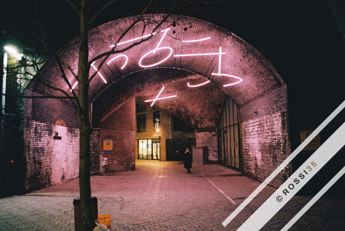 Neon under a brick railway arch